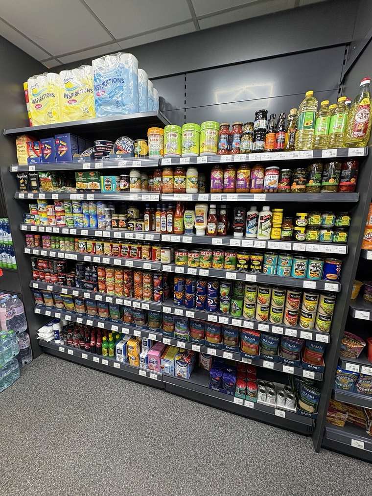 Groceries, cooking sauces, oils, tinned food and spices displayed at C&K Local Store in Worcester.