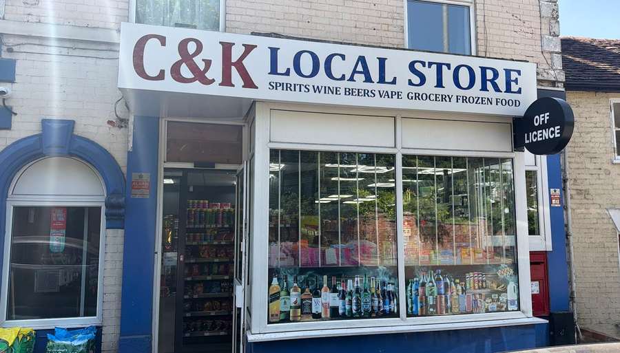 The C&K Local Store shopfront on London Road, Worcester, with its navy-blue frontage and Off Licence sign.